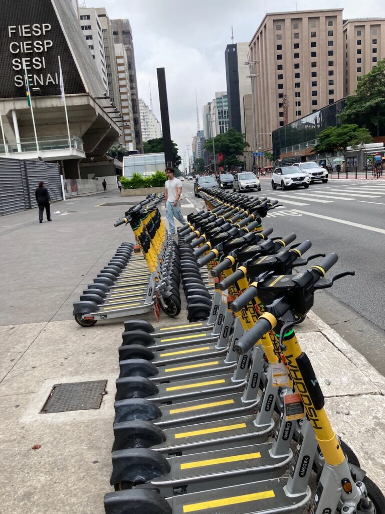 A view of a row of rental scooters on Avenida Paulista near Trian-MAP station in São Paulo