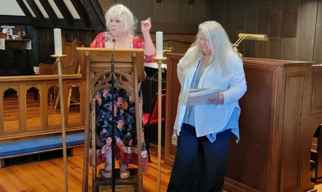 Kristin Frangoulis (left) and KaRyn Kuchenbaur, the Evergreen Press editors of “Tyranny! Maine Poets Decry the Demise of American Democracy,” speak at the June 6, 2026 book launch in Belfast, Maine. (Photo by Jeffrey B. Roth)