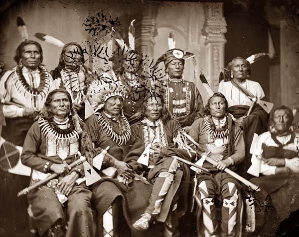 Studio portrait of Indigenous American chiefs in 1865. Via Wikimedia Commons.