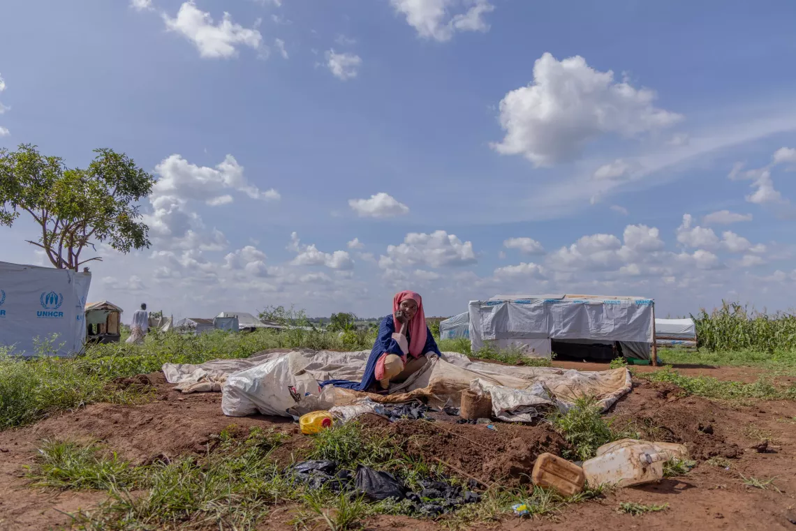 UNI5528480.JPG Watsemba Nasreen Hassan, a new arrival in Kiryandongo refugee settlement, and a single mother of one, with the remains of her old house after the winds waved it down. Nasreen is among the 99 women at risk who are set to receive cash packages to start businesses. Nasreen hopes to start a cooking business where she specialises in Sudanese food. 22 November 2024. UNICEF/UNI687529/